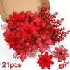 A bouquet of artificial red and deep pink flowers and berries displayed in a cardboard box.