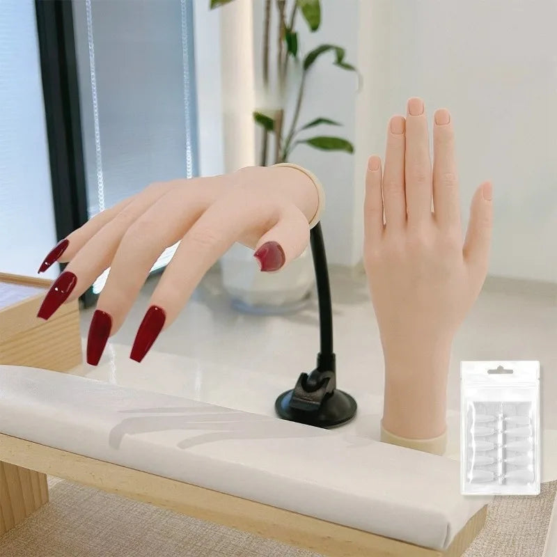 A hand model with artificial nails is shown resting on a white surface next to a silicone nail practice tool.
