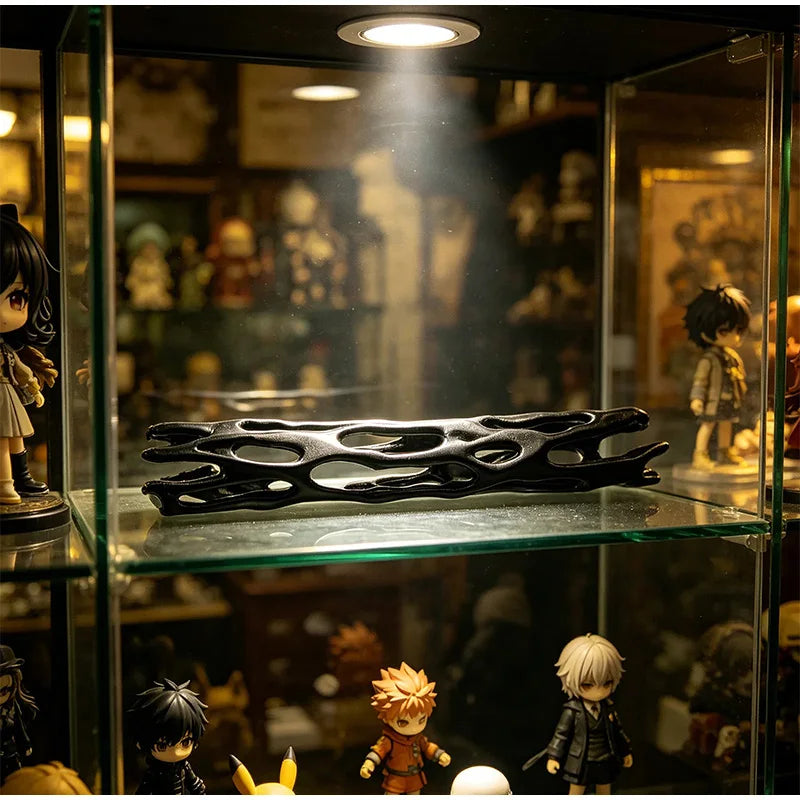 A black 3D printed wishing willow stick with a breakable wish box displayed in a glass cabinet.