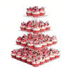 A tiered stand displaying numerous cupcakes with red and white frosting and sprinkles.