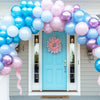 Un arc de ballons vibrant avec des ballons roses et bleus encadrant une porte bleu clair.