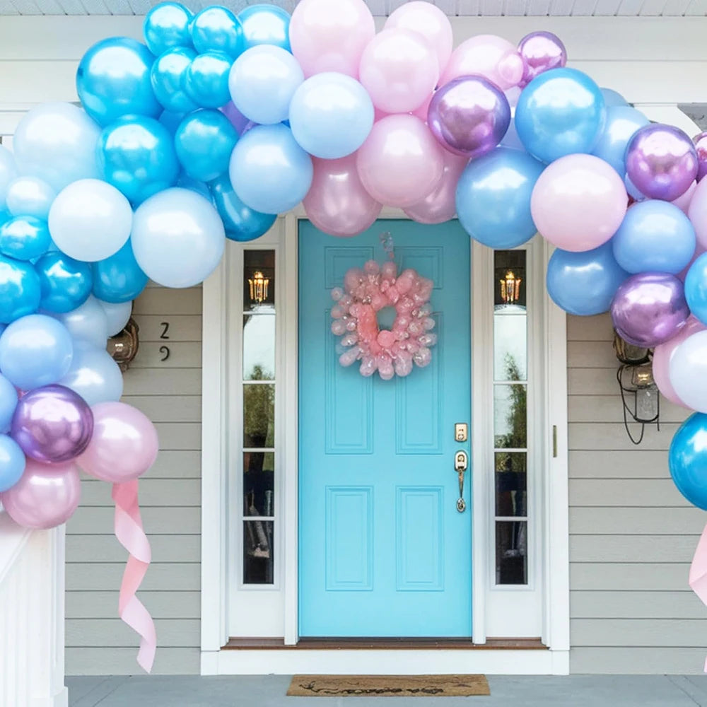 Un arc de ballons vibrant avec des ballons roses et bleus encadrant une porte bleu clair.