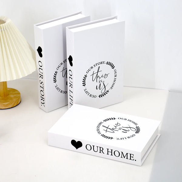 A set of three modern decorative fake books in white featuring the text Our Story This Is Our Life and Our Home.