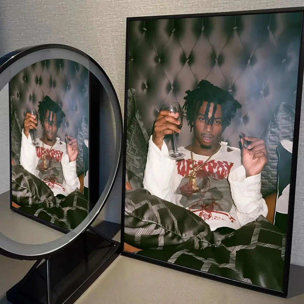 A framed photograph of Playboi Carti in a white shirt and gold chain, displayed next to a round mirror.