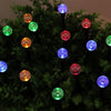 A cluster of green foliage illuminated by glowing, colorful LED bubble lights.