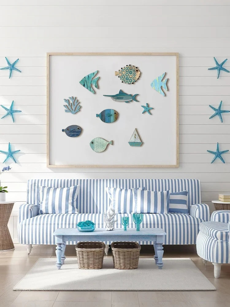 A display of ten wooden hanging fish wall decorations in various shades of blue and teal against a white wooden panel.