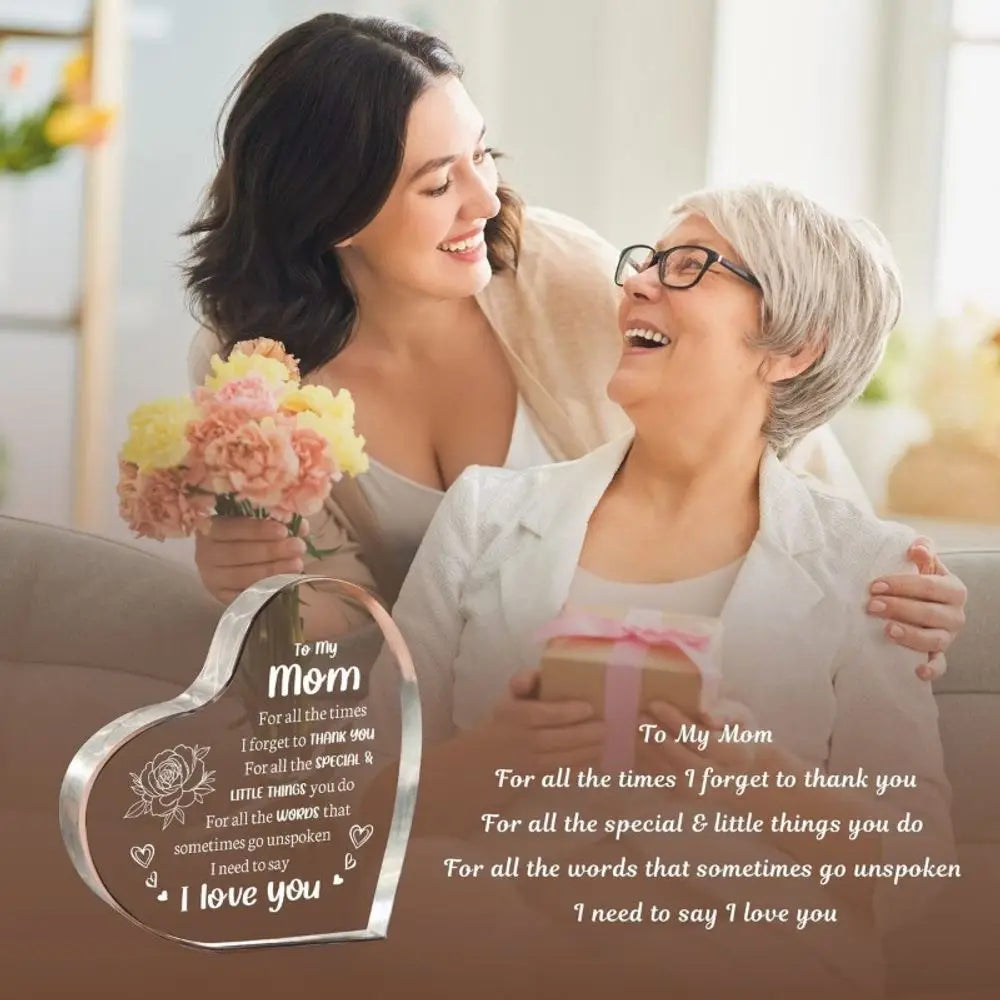 A woman is hugging an elderly woman, with a heart-shaped acrylic keepsake for mom visible in the foreground.