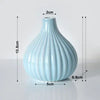 Light blue ceramic flower vase with vertical ribbed texture.