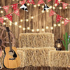 A rustic western backdrop featuring a wooden guitar, hay bales, and decorative pennant banners.