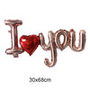 Gold foil letter balloons spelling I love you with a red heart shape
