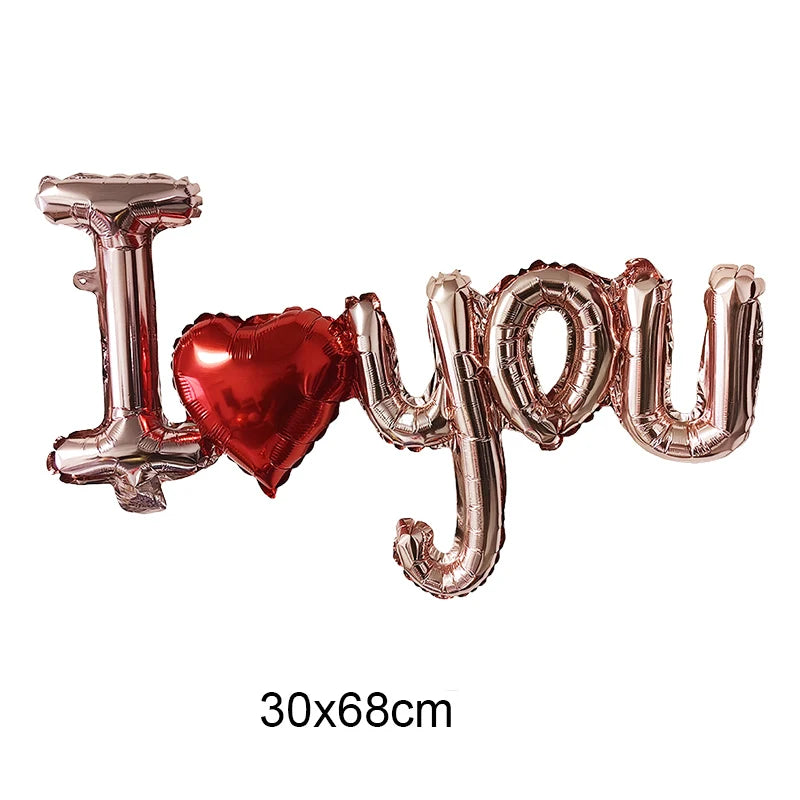 Gold foil letter balloons spelling I love you with a red heart shape