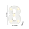 A white alphabet letter light shaped like the number eight with glowing warm white LEDs