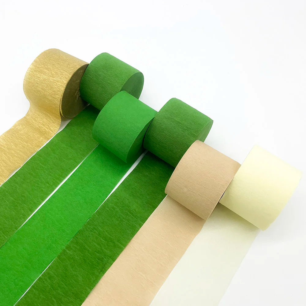 Ein Set Regenbogen-Krepppapier-Girlanden in verschiedenen Grüntönen, Gelb- und Beigetönen, gerollt in Streifen.
