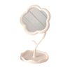 A light pink makeup mirror shaped like a sunflower heart with a scalloped frame.