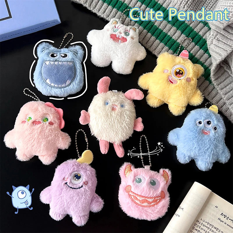 A collection of cute fuzzy plush monster keychains in various pastel colors like white, yellow, pink, and blue.