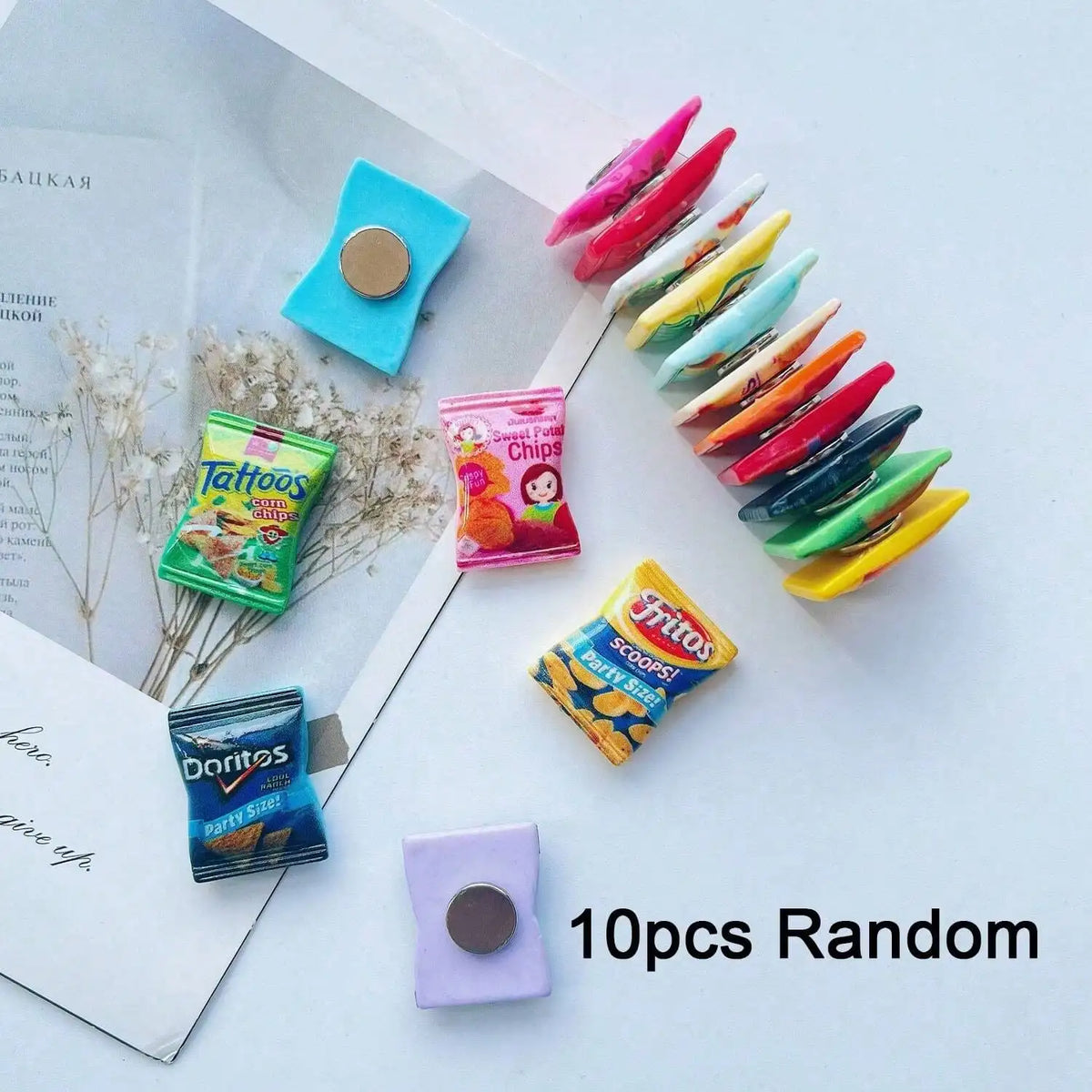 A collection of ten colorful candy-shaped refrigerator magnets in various shades and shapes.