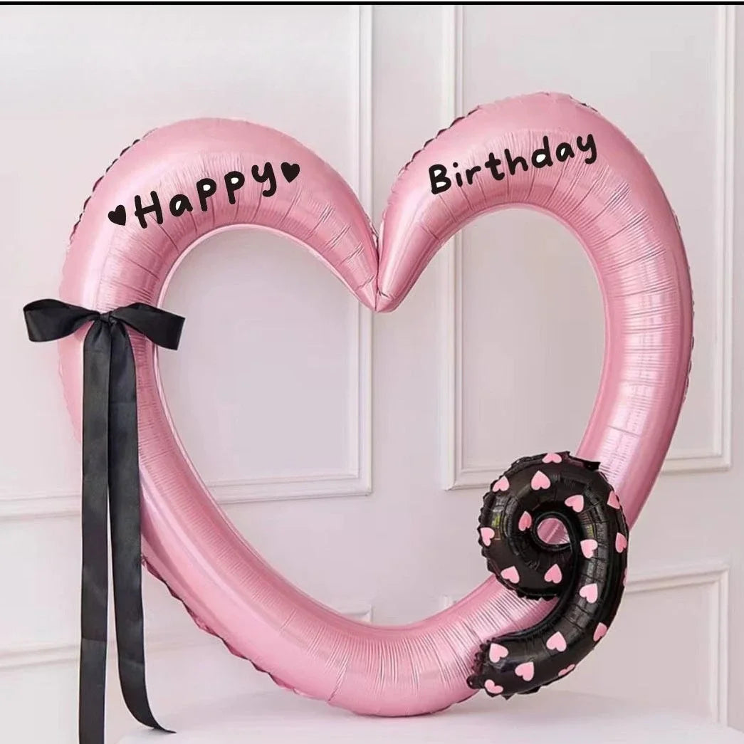 Pink heart-shaped balloon decoration with Happy and Birthday text