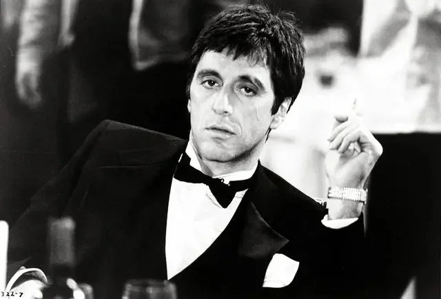 Photo noir et blanc d'un homme en smoking, regard intense, probablement du film Scarface.