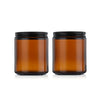 A set of two amber glass jars with black airtight lids and labels