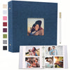 A dark blue linen scrapbook album with a square window displaying a photo of a woman's face and a wooden pen.