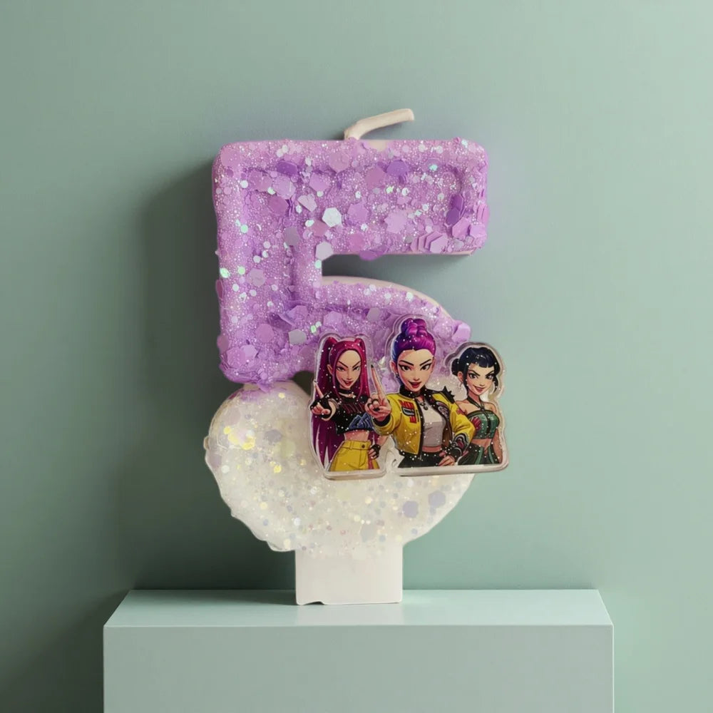 A purple glitter candle shaped like the number five, featuring three character figures on the base.