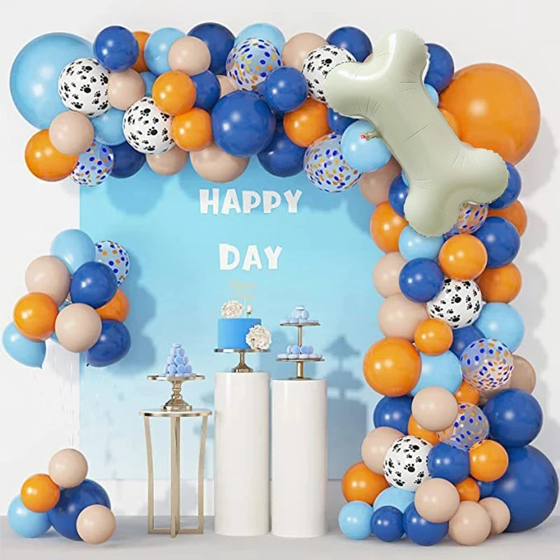 A balloon garland featuring dog paw and bone shapes in blue, orange, and beige colors for a birthday party decoration.