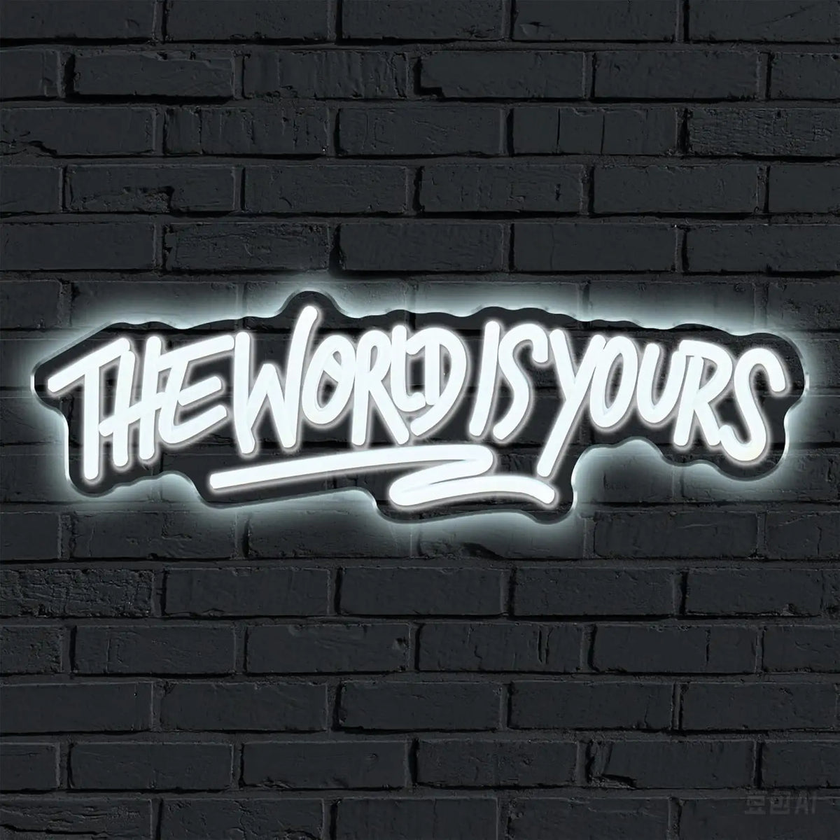 A glowing neon sign on a dark brick wall reads The World Is Yours