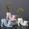 A collection of ceramic cartoon cat planters in various shades of pink and white, featuring succulent plants.