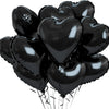A bunch of glossy black heart-shaped foil balloons tied together.