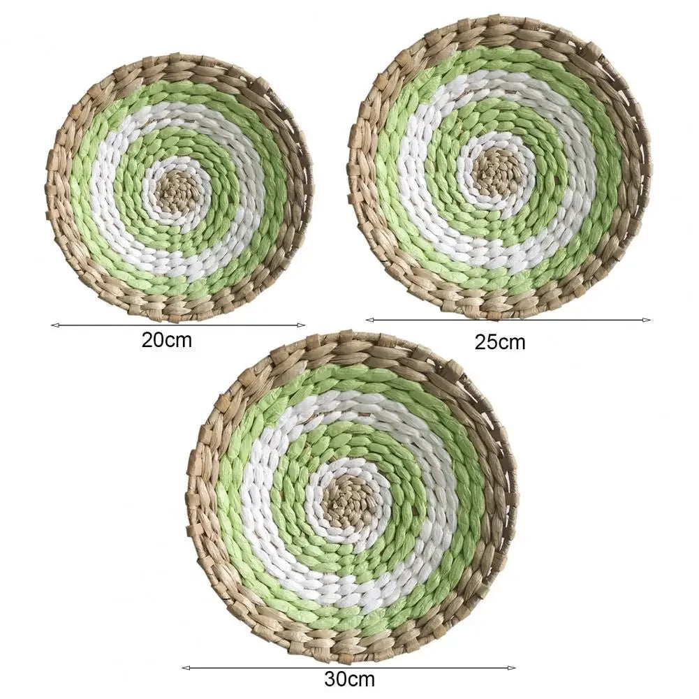 Three circular bohemian straw wall decor hangings of increasing size, featuring concentric rings of natural and light green f