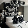 A display of silver and black balloons spelling out Happy Birthday and a heart for party decorations