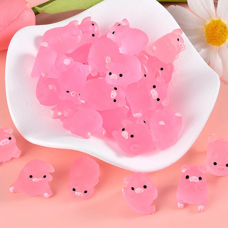A pile of pink glow-in-the-dark mini pig figurines arranged on a white dish.