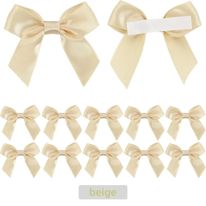 A set of beige satin ribbon bows with white self-adhesive backing for crafting and gift wrapping.