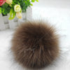 Pompon en boule de fourrure synthétique marron et moelleuse.