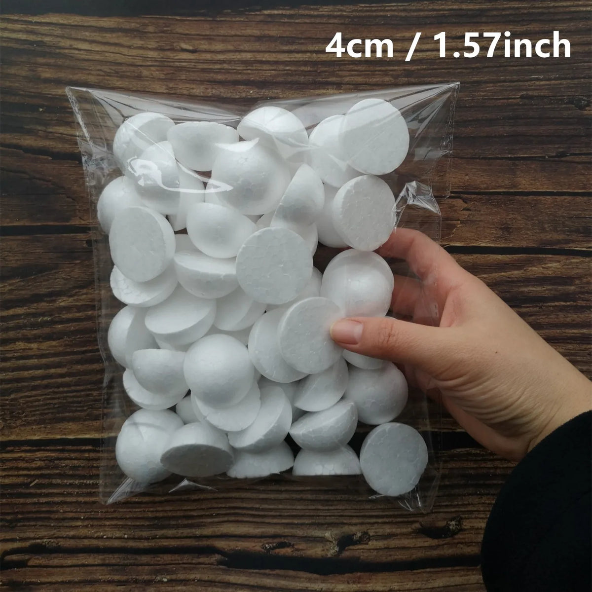 A hand holds a clear plastic bag filled with white polystyrene foam balls for crafting and decorating.