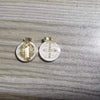 A pair of silver religious pendants featuring St. Benedict imagery, used for crafting or gifting.