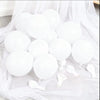 A collection of white latex balloons arranged on sheer white fabric for celebrations