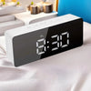 A black LED digital alarm clock displaying 8:30 on a white sheet.