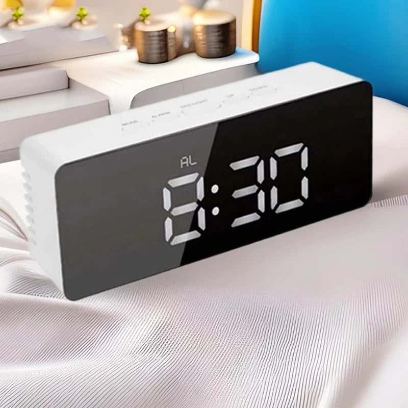 A black LED digital alarm clock displaying 8:30 on a white sheet.
