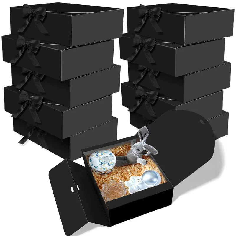 A black gift box is open, revealing a rabbit figurine and some treats inside.
