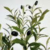 A branch of artificial olive tree leaves and small black olives on a stem.