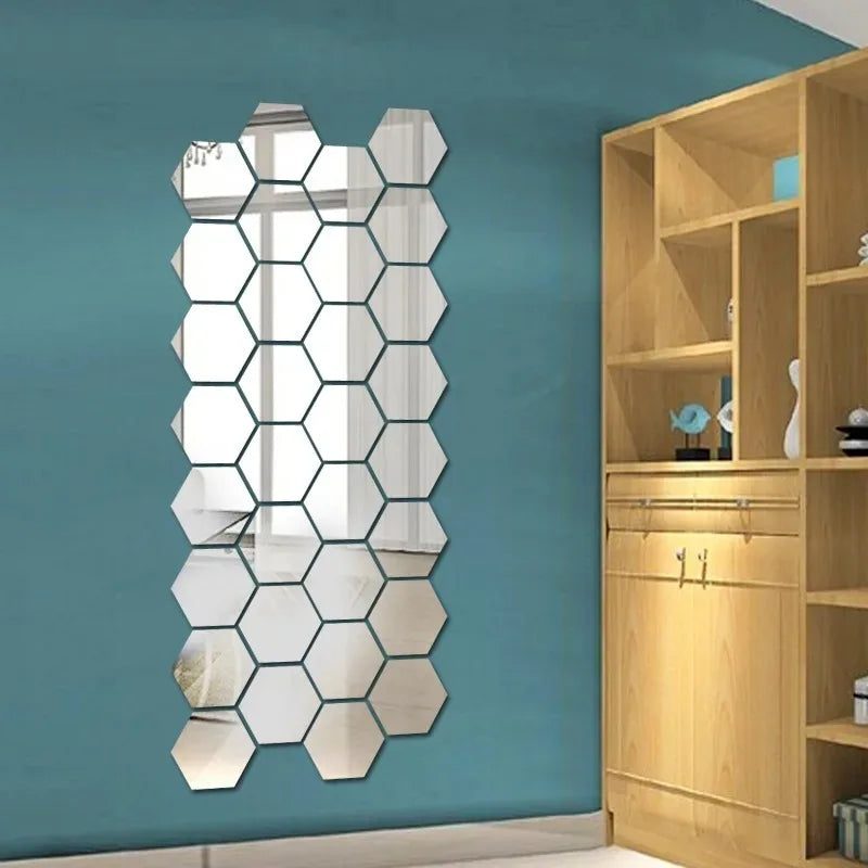 A vertical, irregular hexagon mirror wall decor sticker mounted on a teal wall next to a wooden shelving unit.