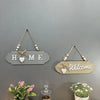 Rustic wooden door welcome sign with the words HOME and Welcome, featuring natural wood and white accents.