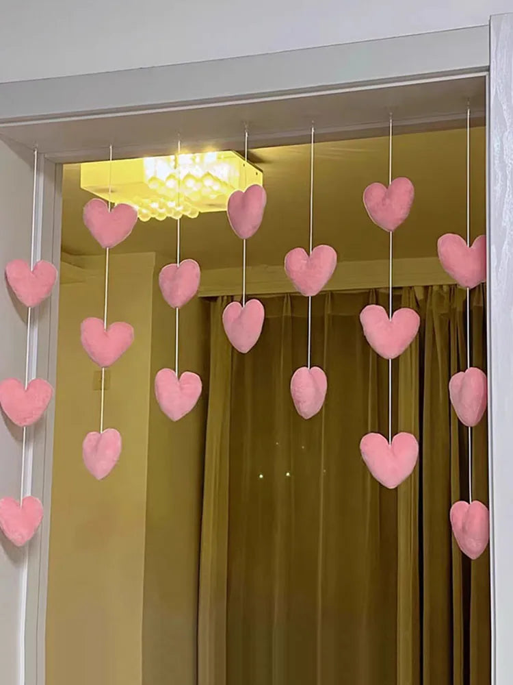 A display of heart-shaped pink string curtains hanging in a doorway.