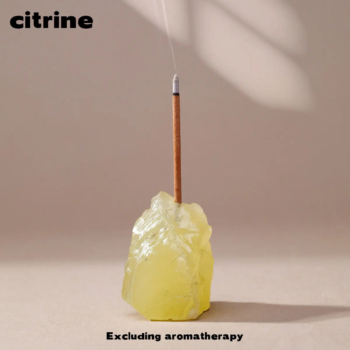 A clear quartz crystal is held by a thin stick, set against a neutral background.