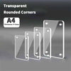 A set of transparent acrylic photo frames with rounded corners displayed on a gray surface.