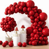 A large arch made of ruby red balloons for weddings and parties, displayed on a wooden surface.