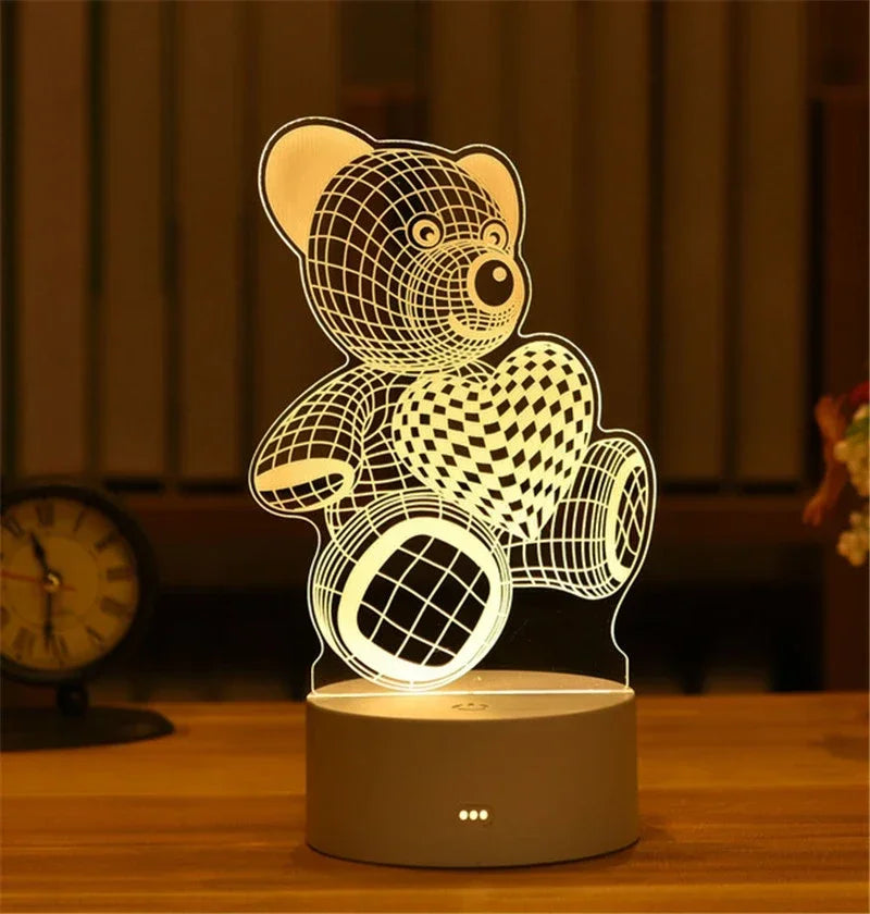A white acrylic LED night light shaped like a teddy bear and a heart, illuminated on a wooden surface.