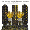 A set of black and gold disposable dinnerware including plates, cups, straws, and napkins displayed on a table.