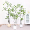 A tall artificial Nandina plant with green foliage in a white pot displayed indoors.